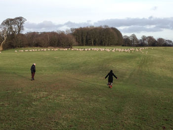 Rear view of two people walking on landscape