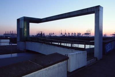 Bridge over river in city against clear sky