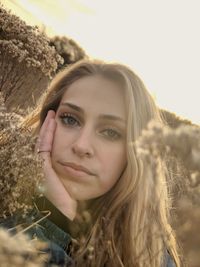 Portrait of young woman against sky