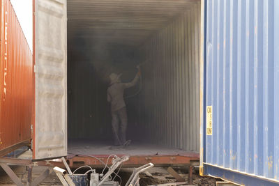 Rear view of man working at window