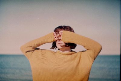 Woman standing on beach against sky