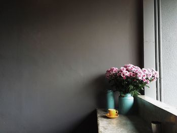Flower vase on table by window at home
