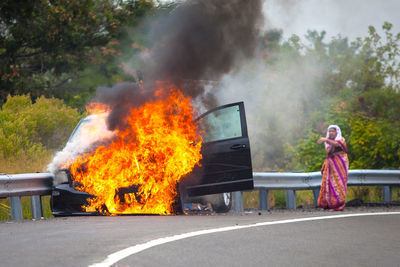 Car on fire with passengers on highway and smoke