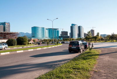 Cars on road in city against clear sky