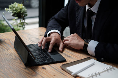 Midsection of man using laptop on table