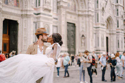 Couple kissing in front of building on street