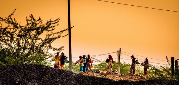 People against clear sky during sunset