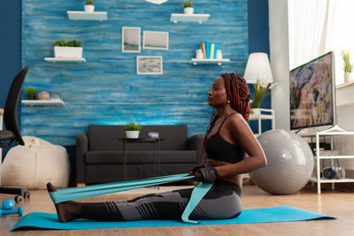 Side view of woman sitting on floor