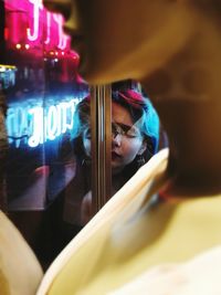 Woman in illuminated mirror