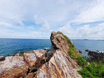 Rock formations on sea shore against sky