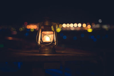 Close-up of illuminated lamp on table at night