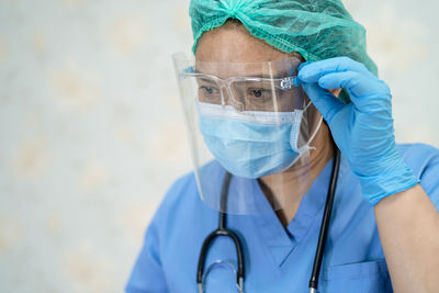 Close-up of doctor wearing mask looking away at hospital