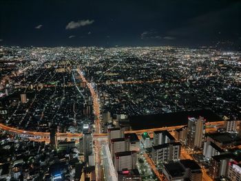 High angle view of illuminated city against sky at night