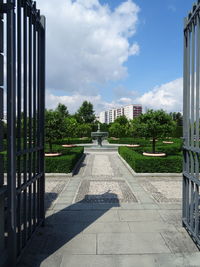 Footpath amidst buildings against sky