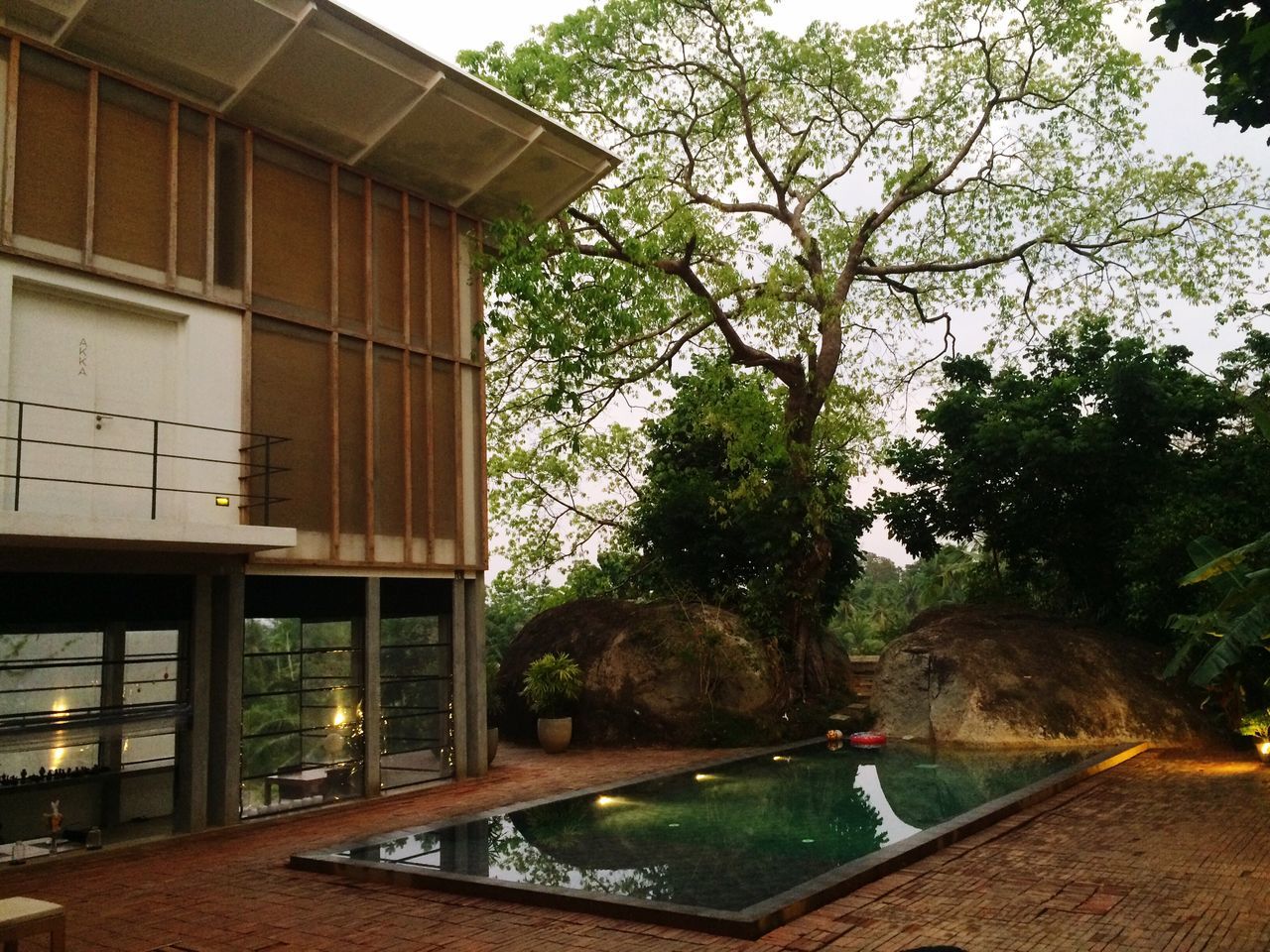 architecture, built structure, building exterior, tree, reflection, water, sky, city, building, outdoors, no people, day, house, residential building, window, sunlight, growth, residential structure, glass - material, street