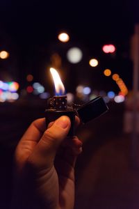 Close-up of hand holding illuminated candles