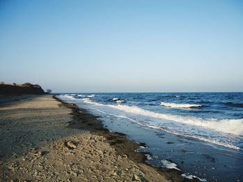 Scenic view of beach against clear blue sky