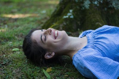 Portrait of woman lying on field