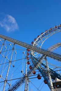 Low angle view of ferris wheel against blue sky