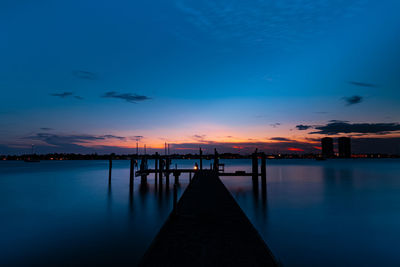 Pier over sea against sky during sunset