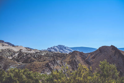 Scenic view of mountains against clear blue sky