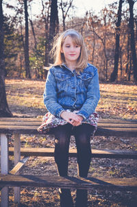 Girl sitting on picnic table at field