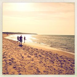 Scenic view of beach against sky at sunset