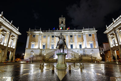 Statue in city at night