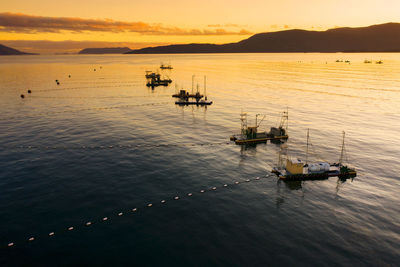 Silhouette boats in sea during sunset