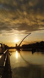 Bridge over river against sky during sunset