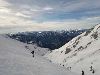 People skiing on snow covered landscape