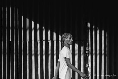 Young woman standing against wall