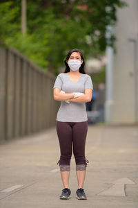 Portrait of woman standing on footpath