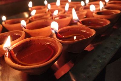 Close-up of lit diyas on table