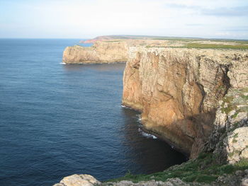 Rock formations by sea against sky