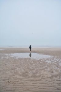 Full length of man on beach against clear sky