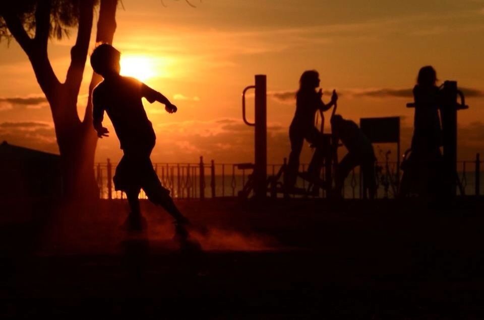 sunset, silhouette, orange color, men, lifestyles, sky, person, leisure activity, sea, medium group of people, large group of people, sun, horizon over water, togetherness, tourist, standing, walking, vacations, travel