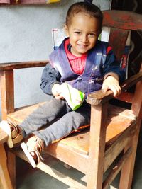 Portrait of smiling boy sitting on chair