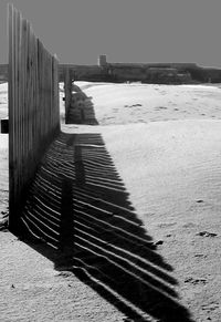 Shadow on sand at beach against sky