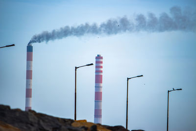 Smoke emitting from chimney against sky