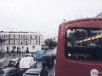 Cars on road seen through wet window during rainy season