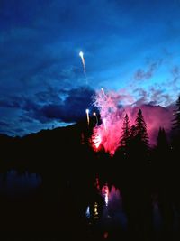 Firework display against sky at dusk