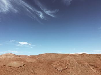 Scenic view of desert against blue sky