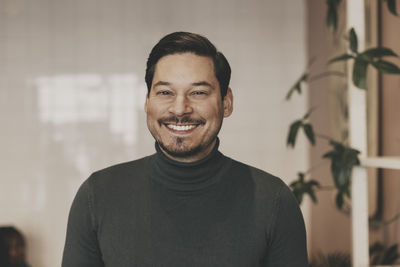 Portrait of happy male business professional at office