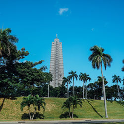 View of trees on landscape against blue sky