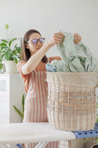 Portrait of smiling young woman standing in basket