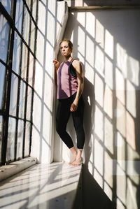Portrait of athlete standing by window in gym