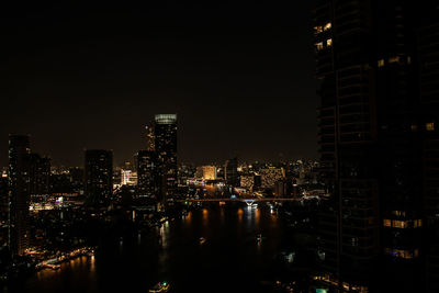 Illuminated buildings in city against sky at night