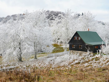 Cottages in early winter scenery with amazing hoarfrost cover in hills ar low mountain in november d