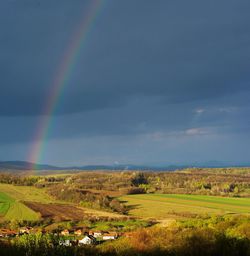 Scenic view of rainbow over field against sky